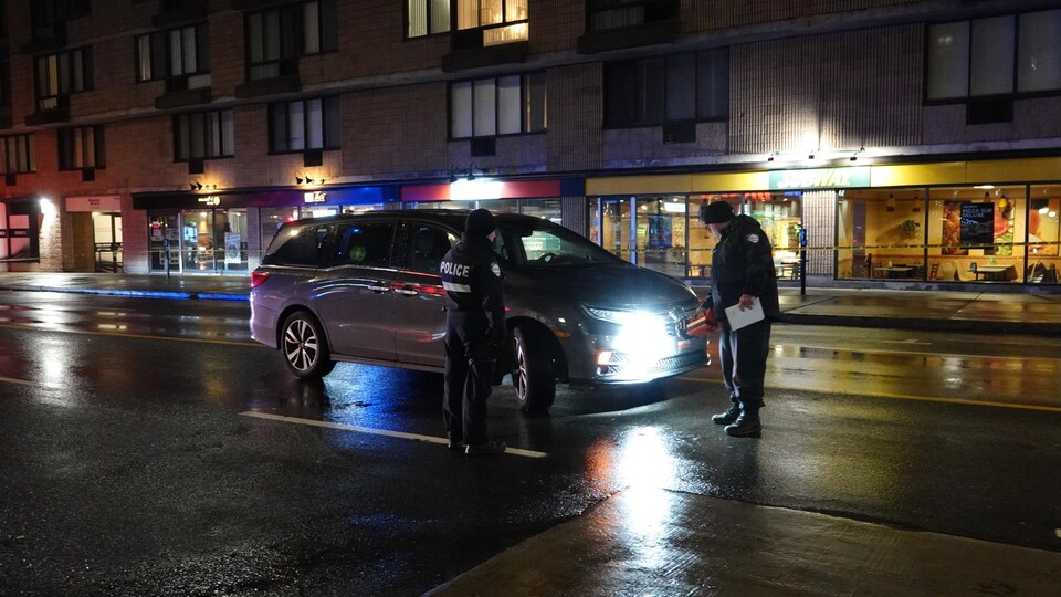 Des policiers inspectent le véhicule impliqué dans l'accident.