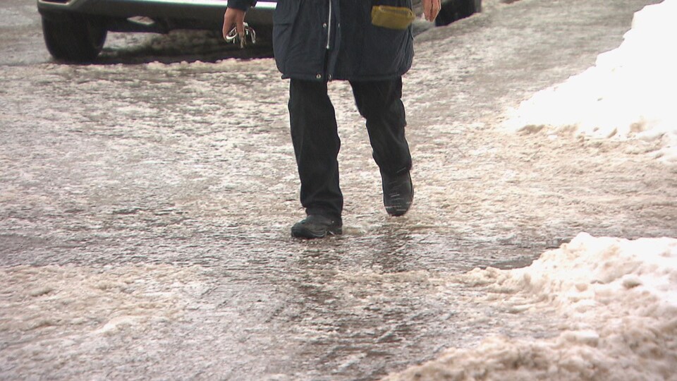 Un piéton marche sur de la glace.