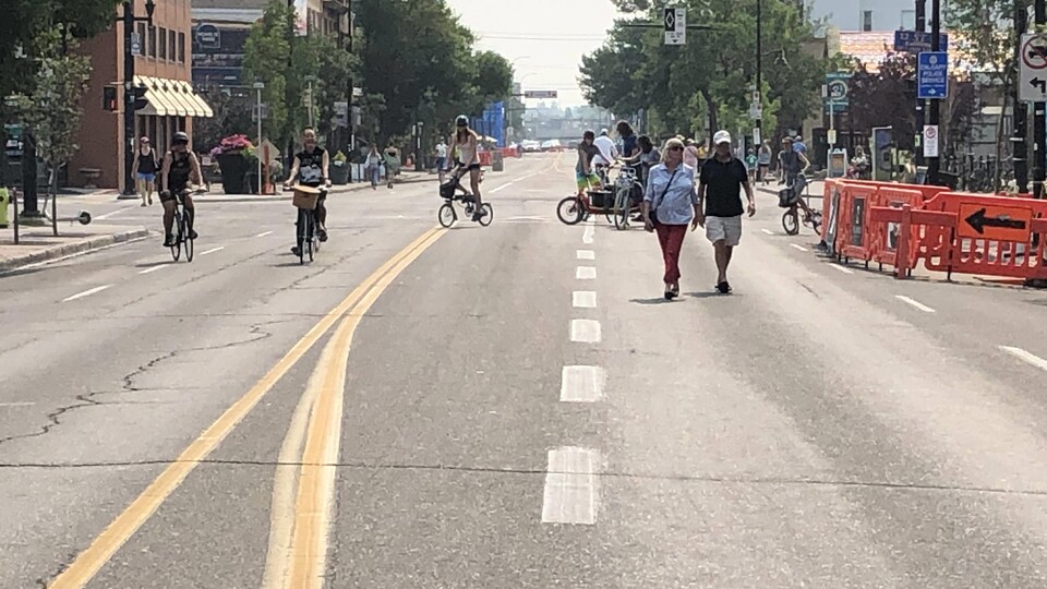 Des piétons et des cyclistes sur une rue.