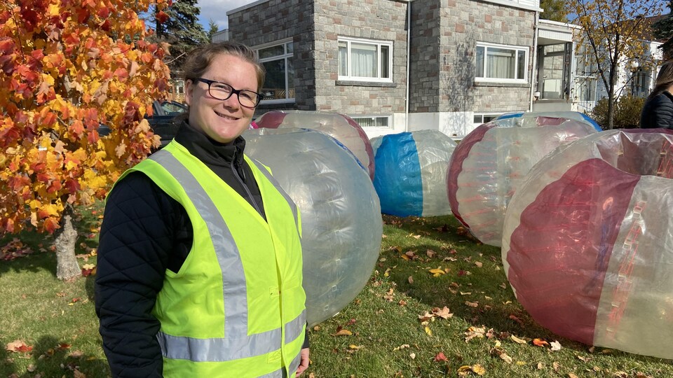 Karine Filteau pose pour la caméra, une série de bulles gonflables en arrière-plan.