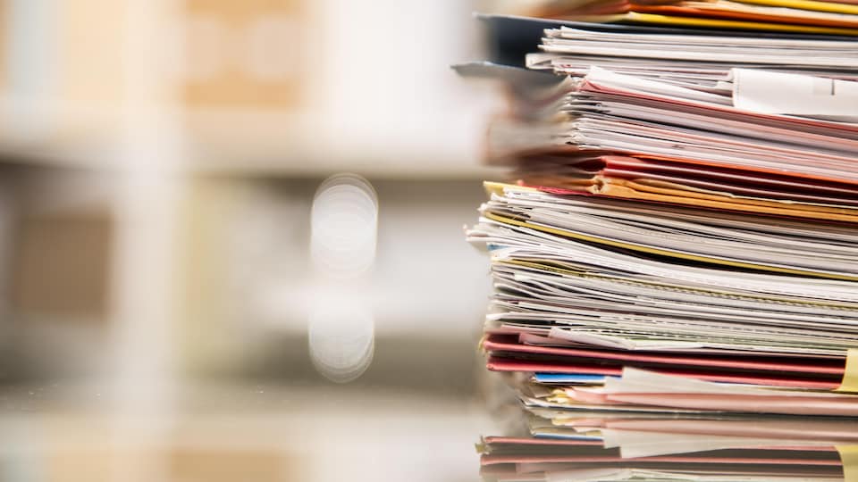 Une pile de documents sur une table.