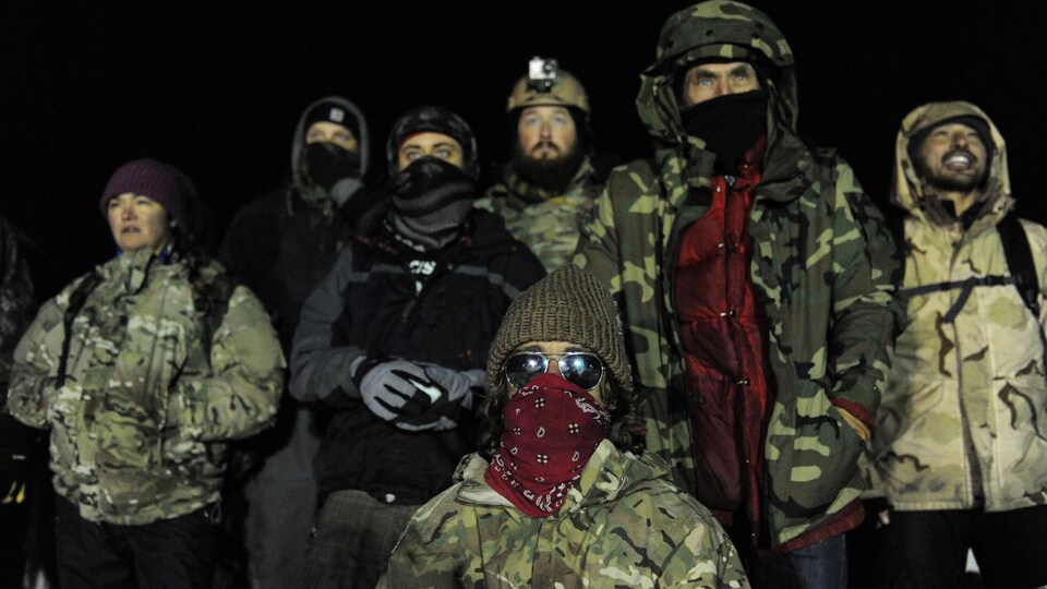 Un groupe d'anciens combattants se tiennent devant les autorités sur le pont Backwater