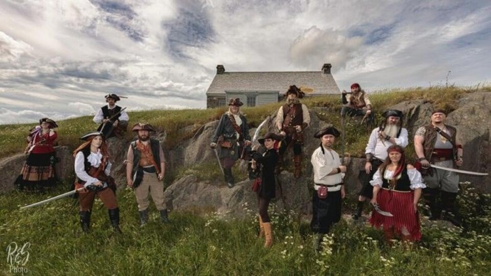L'équipe de pirates nommée les les Raiders of the Avalon Pirate Crew sont placés devant un maison, dans une vallée.
