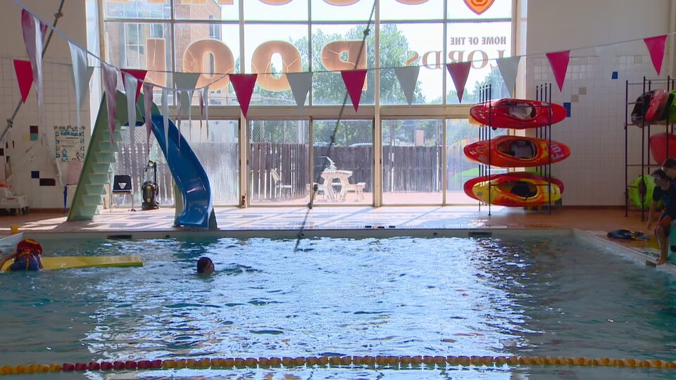 Un nageur se déplace près d'un toboggan dans la piscine Scona.