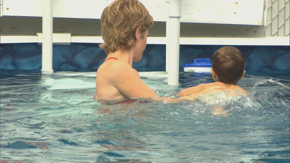 Une femme et un enfant dans une piscine.