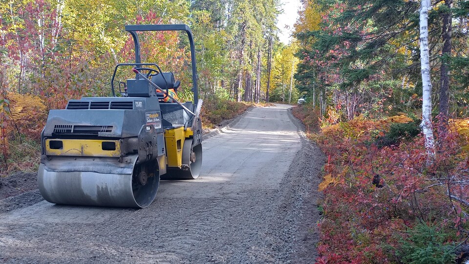 Un compacteur est sur un sentier de gravier.