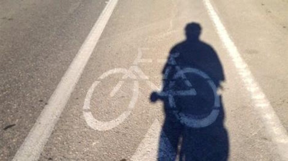 L'hombre d'un cycliste sur une piste cyclable à Winnipeg.