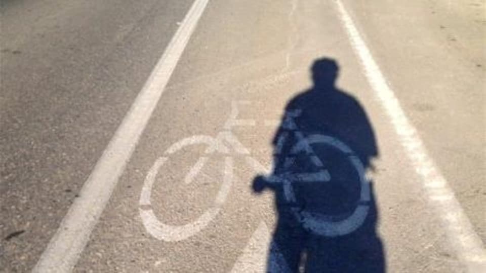 L'ombre d'un cycliste sur une piste cyclable à Winnipeg.