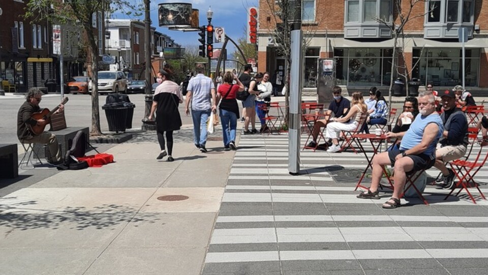 Des gens attablés sur une place publique de Québec
