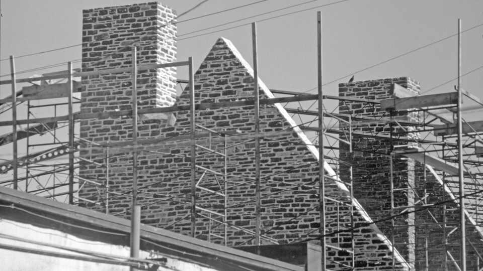 Place-Royale en cours de reconstruction, en 1971. Des échafaudages courts à travers les édifices, sur un ciel visiblement bleu et ensoleillé.