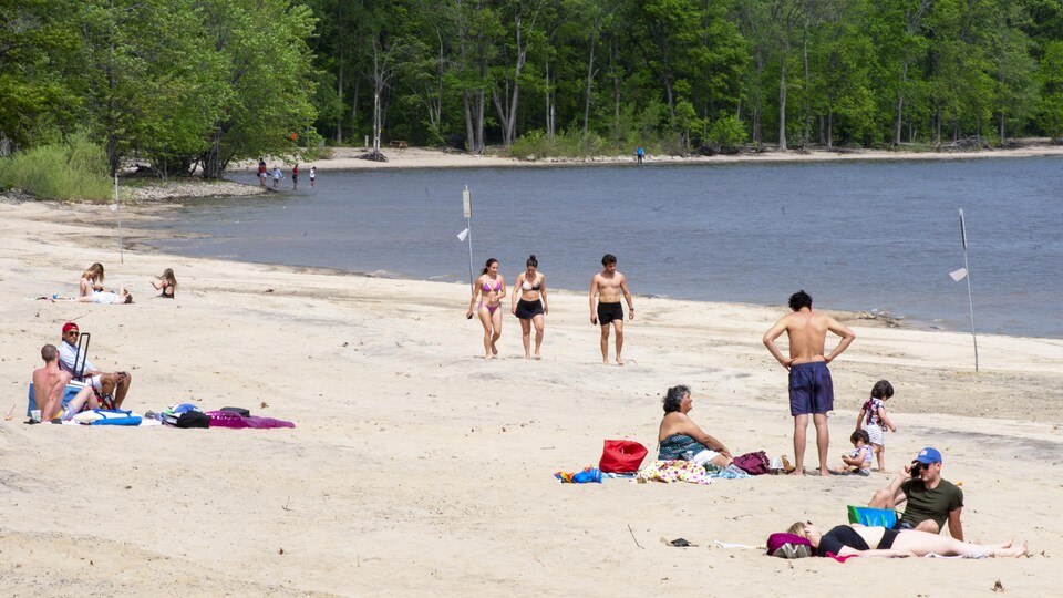 Une dizaine de personnes sur la plage d'Oka.