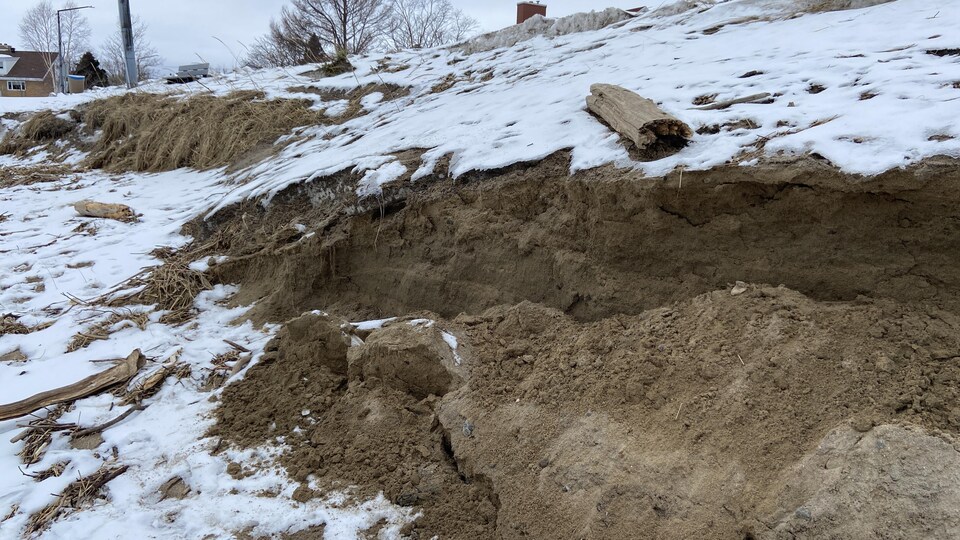 Une plage sous la neige a été érodée par le passage d'une tempête.