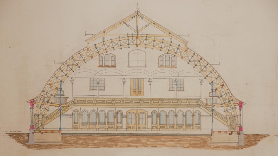 Un plan de coupe montre une partie de la galerie intérieure, ainsi que les fenêtres et les escaliers des deux étages de la partie habitable. On voit bien la forme d'arche qui couvrait l'ensemble de la patinoire. 