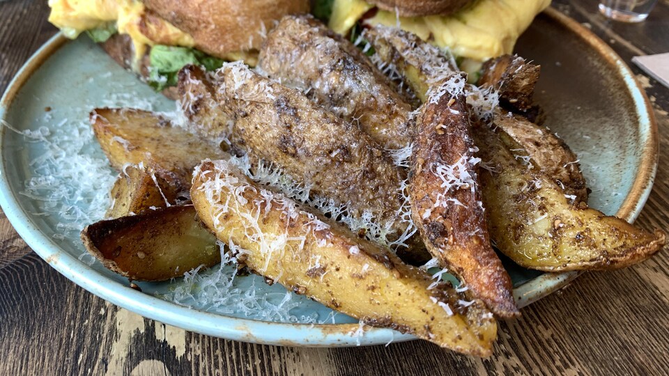 Un plat avec un sandwich et des pommes de terre dans un restaurant.