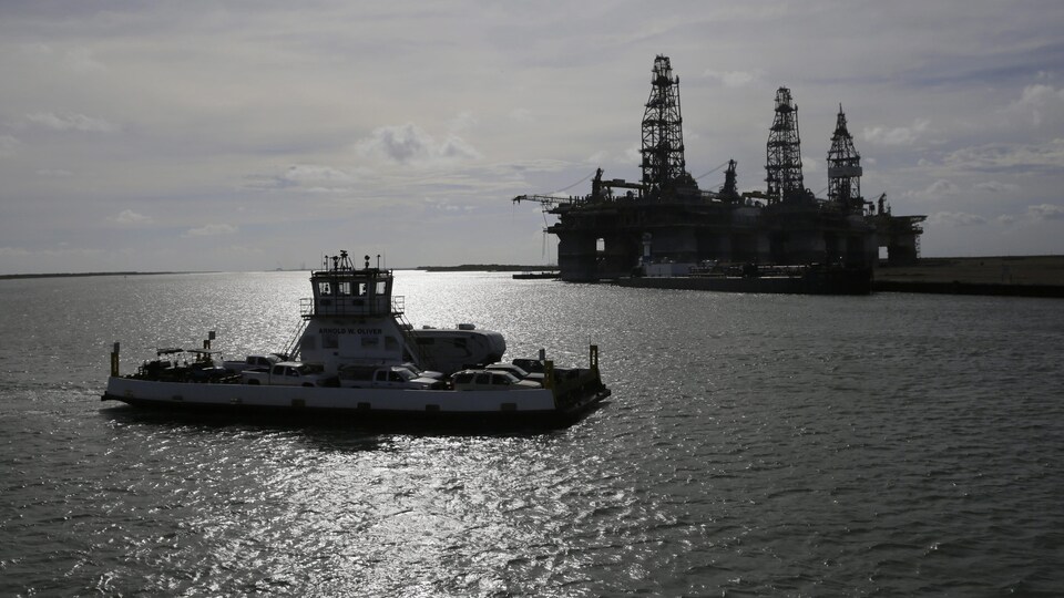 Un traversier évacuant des résidents de Port Aransas, au Texas, passe devant une plateforme pétrolière.