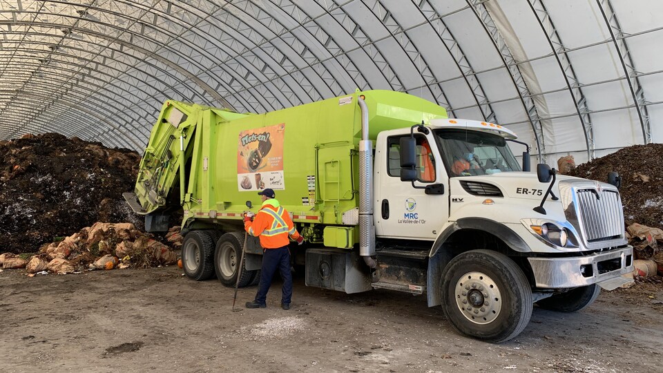 Un camion décharge les matières organiques sous le dôme au site de compostage.