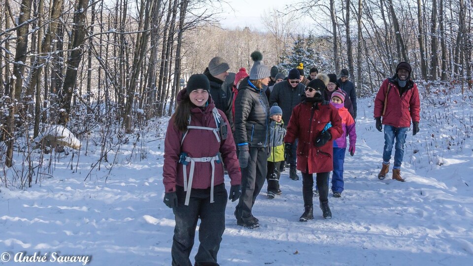 Des Québécois et des personnes immigrantes marchent dans un sentier du parc du Mont-Bellevue.