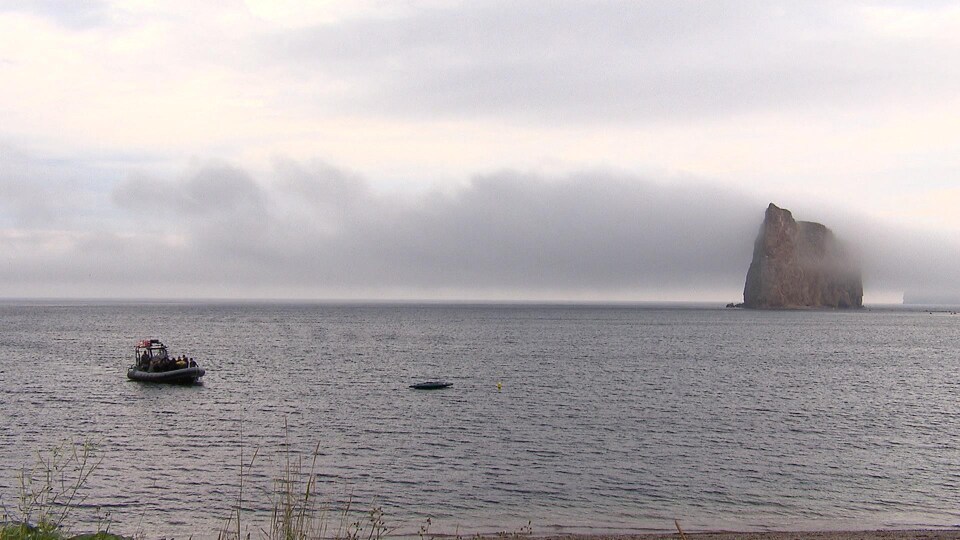 Un pneumatique sur l'eau devant le rocher Percé