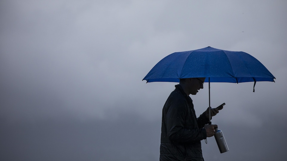 Un homme tient un parapluie.