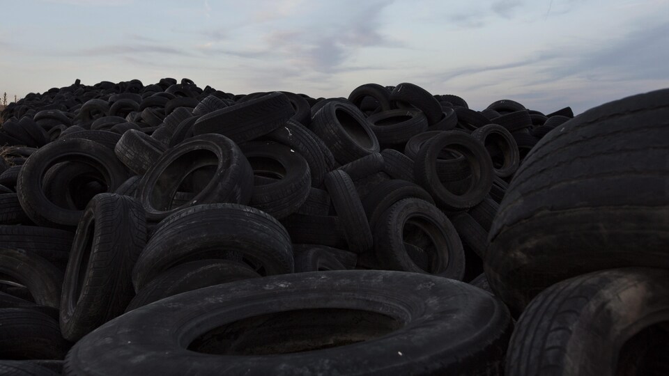 Une montagne de pneus usés dans un dépotoir.