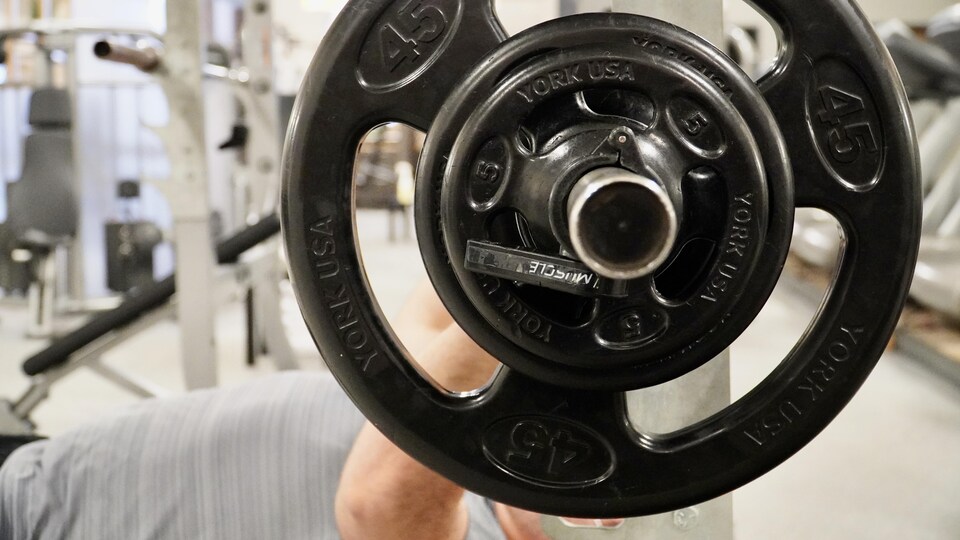 Un homme soulève des poids dans une salle d'entraînement.