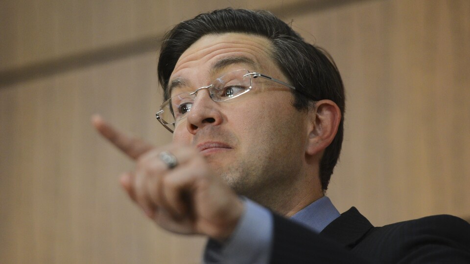 Gros plan de Pierre Poilievre, montrant du doigt.