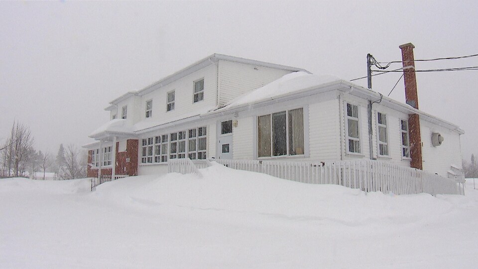 L'ancienne école est photographiée alors qu'une bordée de neige est en train de tomber.