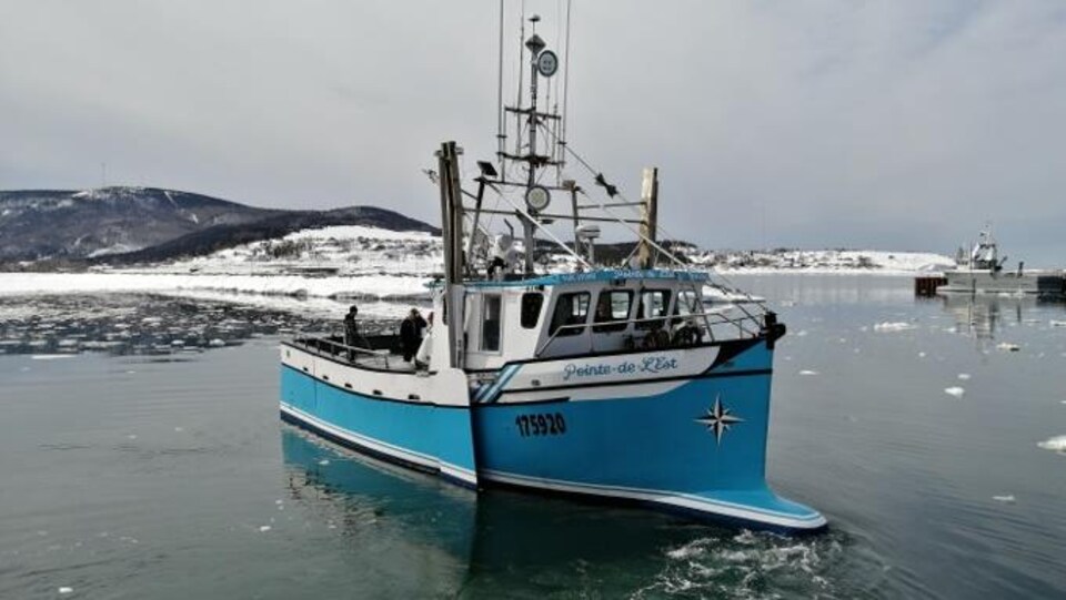 A 45-foot boat slipped into the water, in front of the snowy landscape.