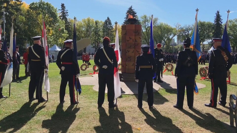 Un groupe de policiers formant un cercle autour d'une structure pour rendre hommage à leurs collègues mort dans l'exercice de leurs fonctions, à Edmonton, le 25 septembre 2022.