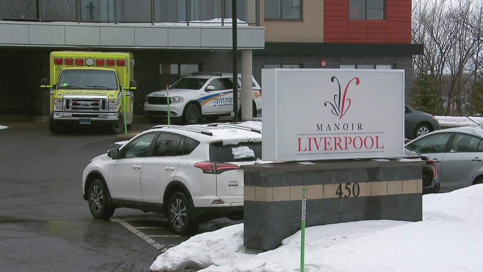 Une ambulance et un véhicule de police devant un immeuble.