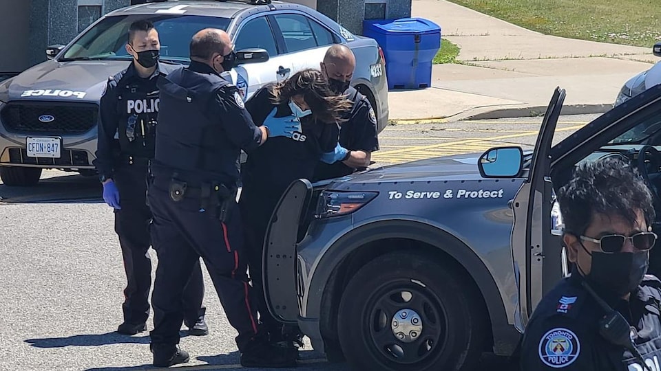 Des policiers maîtrisent un homme.