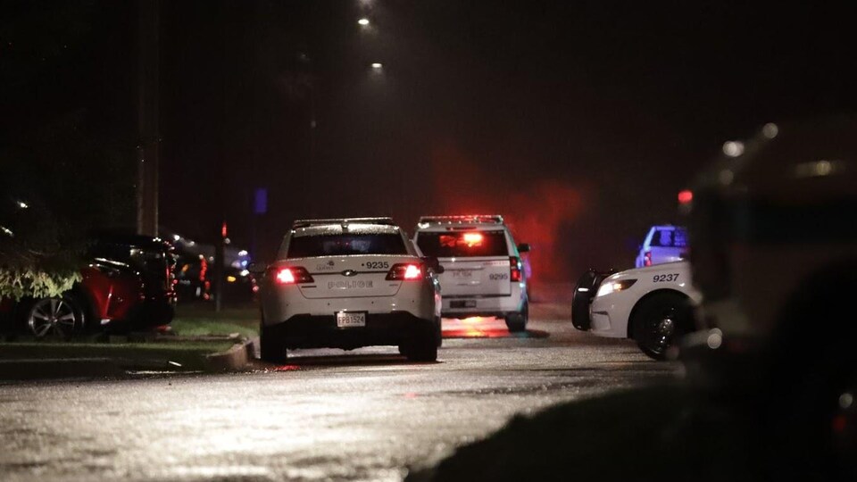Plusieurs voitures de police dans la rue des Bolets à Québec la nuit.