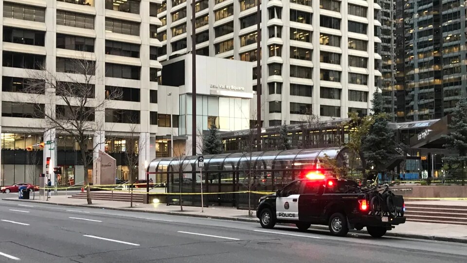 Une voiture de police devant un abri de bus.