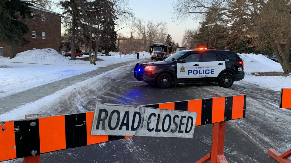 Une voiture de police stationnée au milieu de la rue. 