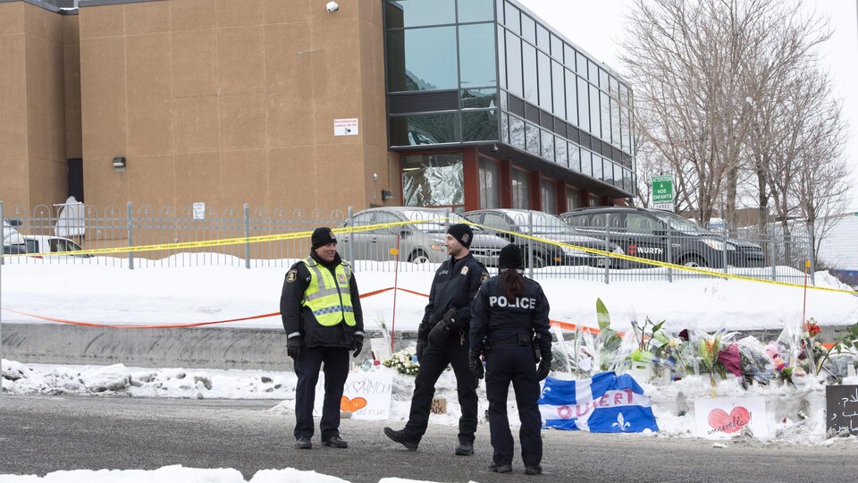 Des policiers de Québec mènent la garde devant un bâtiment abritant une mosquée.