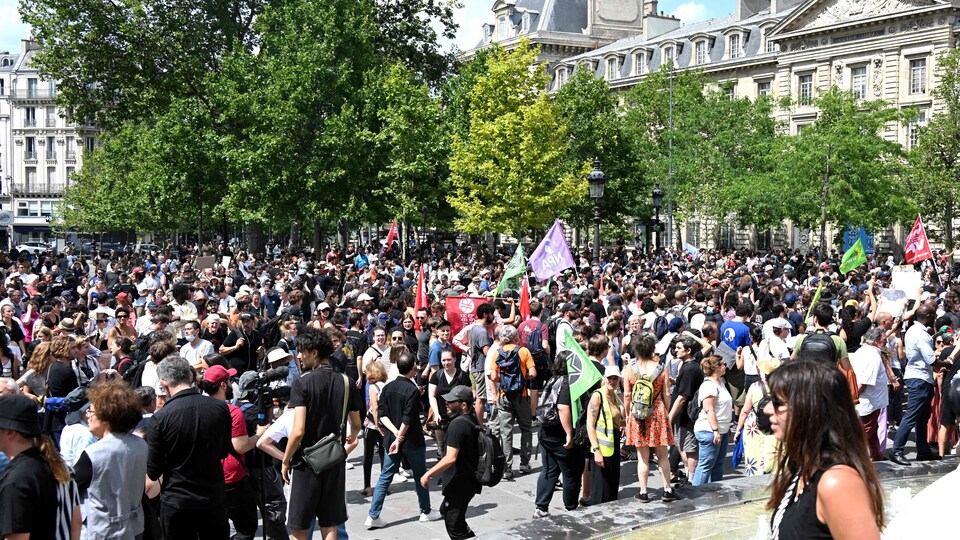 Une foule rassemblée à l'extérieur manifeste à Paris.