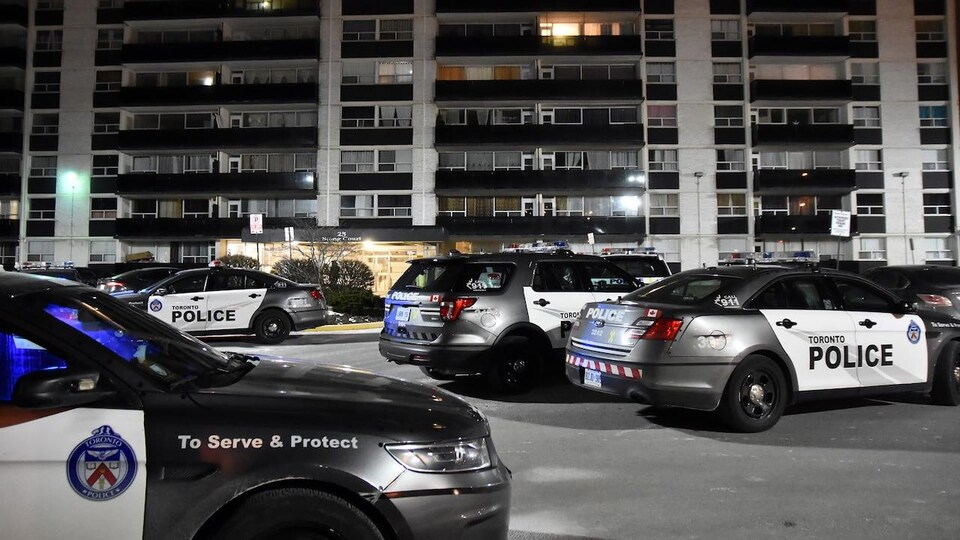 Six véhicules de police devant l'immeuble où la fusillade a eu lieu.