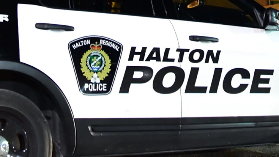 Le côté d'une voiture de police où il est inscrit HALTON en grosses lettres.