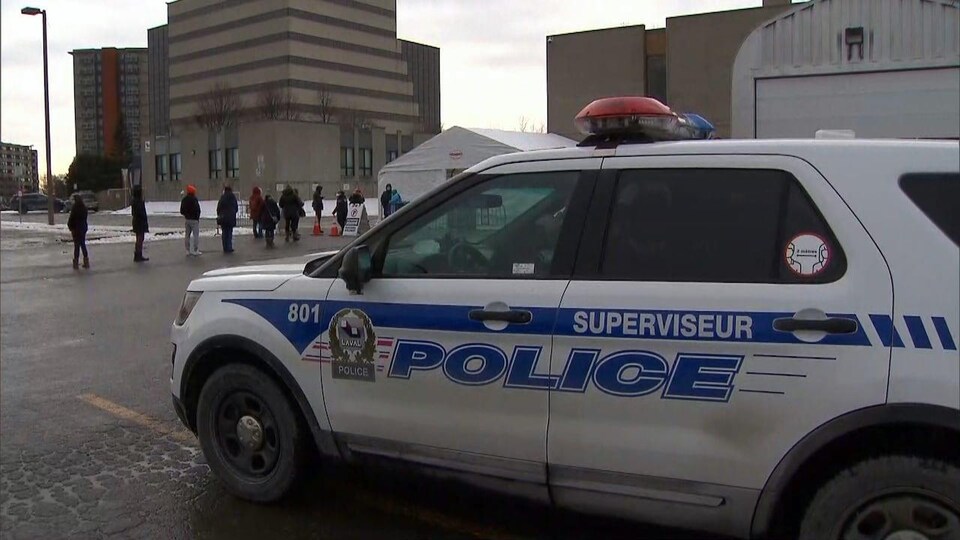 Un véhicule du Service de police de Laval est garé devant un centre de dépistage de la COVID-19.