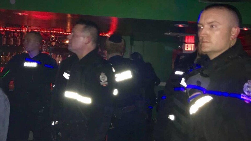Une poignée de policiers à l'intérieur du Nyala Lounge, en soirée.