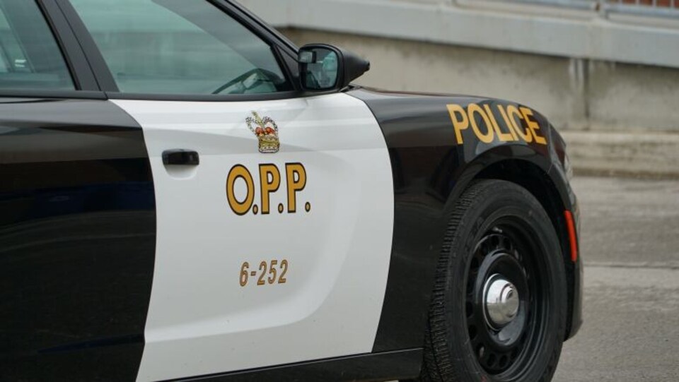 Photo du côté d'une autopatrouille blanche et noire portant les inscriptions « police » et « OPP »