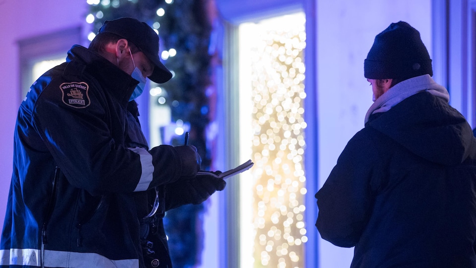 Un policier de la Ville de Québec remet un constat d'infraction.