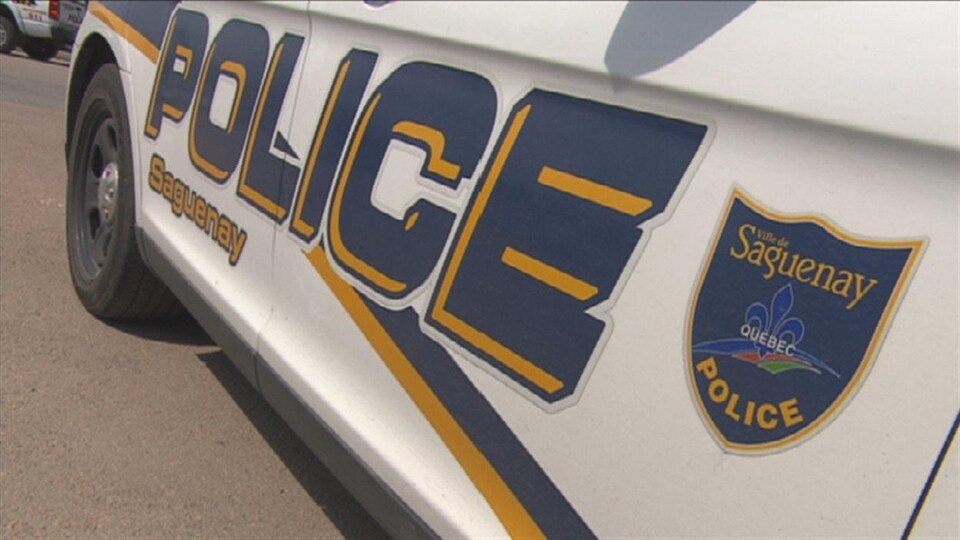 Un véhicule du Service de police de Saguenay est garé dans un stationnement.