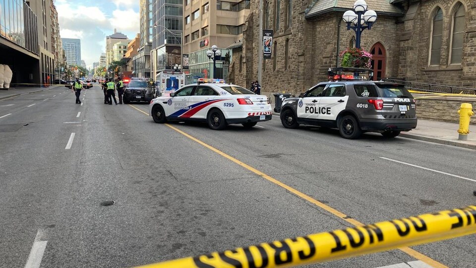 Des véhicules de la police de Toronto bloquent une rue du centre-ville.
