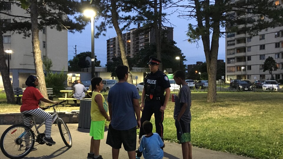 Un policier et des jeunes dans un parc