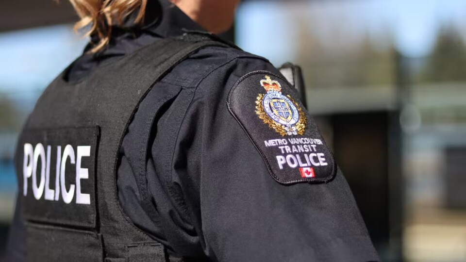 Une agente de la police des transports du Grand Vancouver vue de dos.