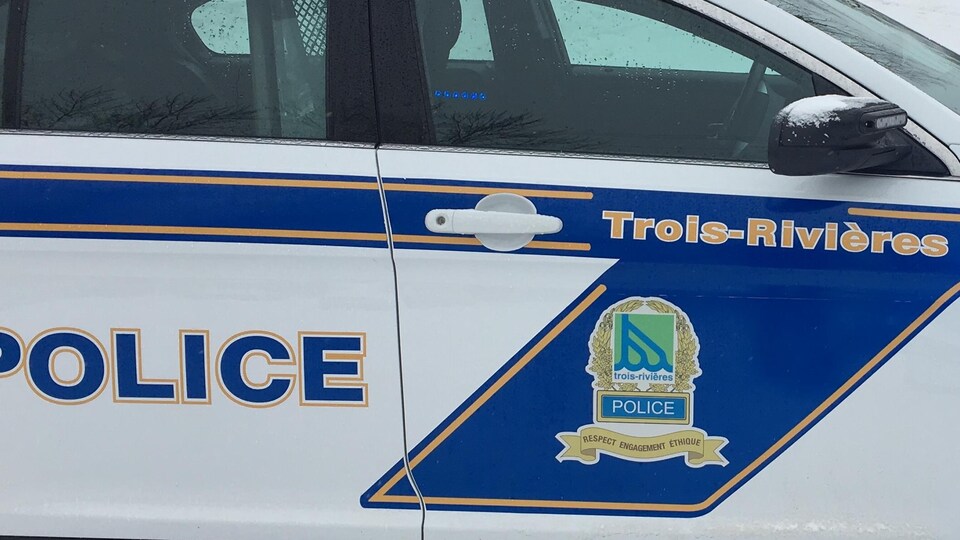 Voiture de police de Trois-Rivières devant le périmètre bouclé dans la rue enneigée.