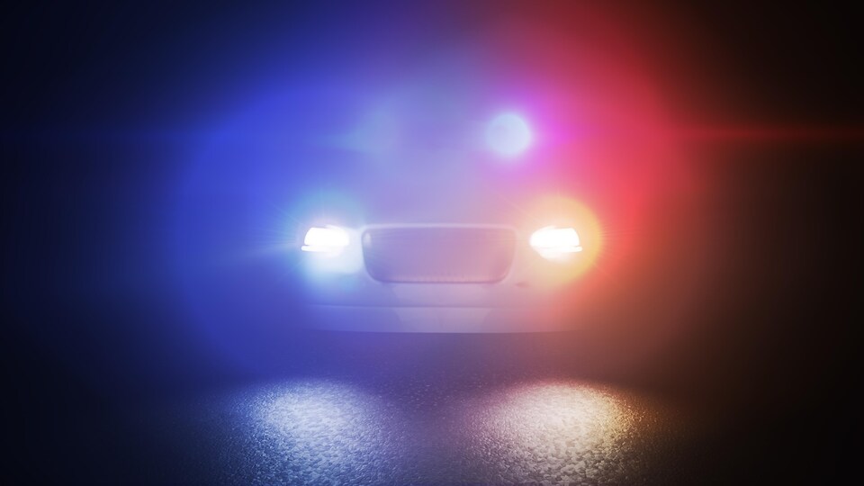 Les gyrophares et les phares d'une voiture de police créent des cercles lumineux.