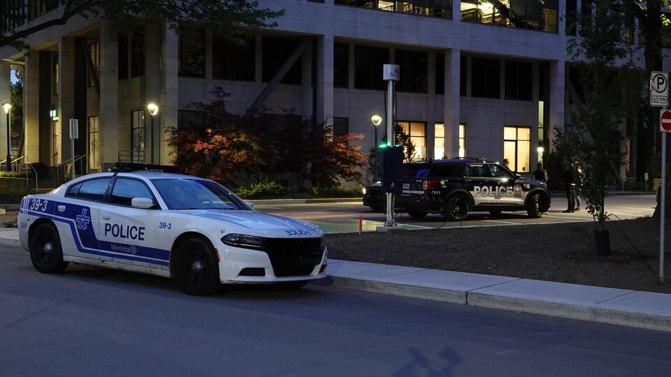 Une voiture de police devant un immeuble.