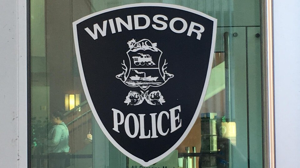 Le blason noir et blanc de la police de Windsor affiché sur une vitre du quartier général.